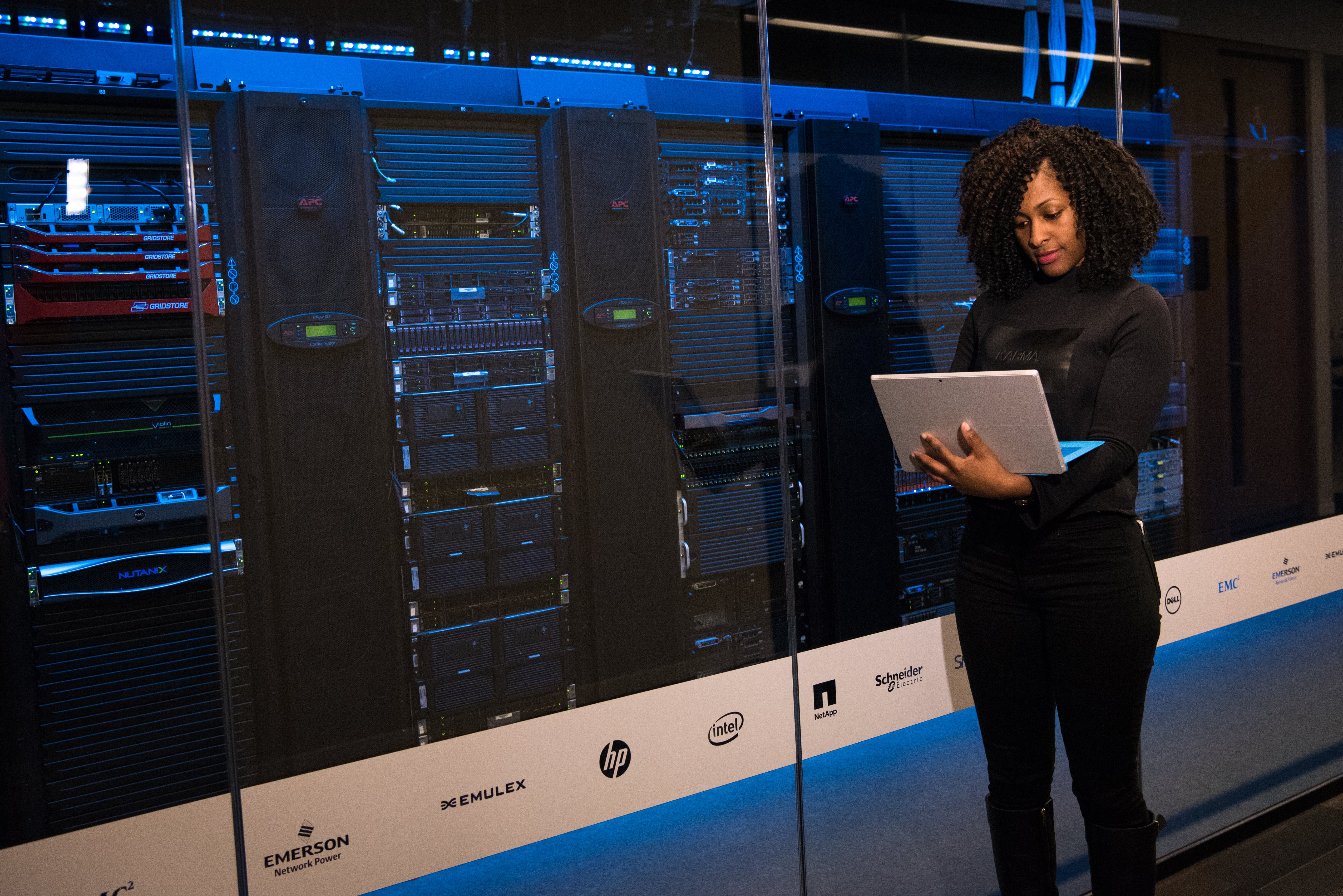 Free Software Engineer Standing Beside Server Racks Stock Photo